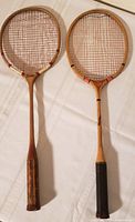Both racquets laid side by side showing full length and grips