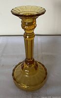 Full view of amber pressed glass candlestick holder standing upright
