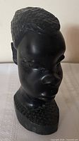 Front view of ebony bust showing face and base pattern