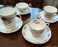 All four cup and saucer sets displayed on table