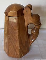 Side view showing tapered paneled body and lid profile