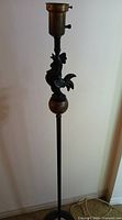 Full view of floor lamp showing rooster, sphere, pole and base segment