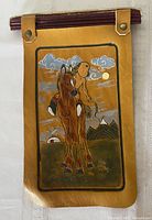 Front view of leather wall hanging showing full artwork and mounting rod