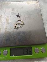 Earrings on digital scale reading 1.36 g