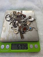 All jewelry pieces on digital scale showing 57.35 g weight