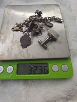 Bracelet, cufflink and earring on digital scale reading 32.36 g