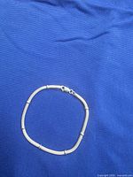 Full view of bracelet closed on blue background