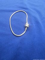 Snake chain bracelet coiled, showing overall look and barrel clasp