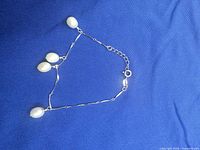Bracelet laid flat showing pearls, clasp and extender