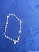 Bracelet partially coiled highlighting blue crystal bezels and lobster clasp
