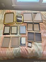 Group of assorted picture frames arranged on bed
