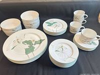 All 27 pieces arranged: soup bowls, plates, cups, saucers