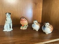 Group shot of dog, robin and two bird figurines