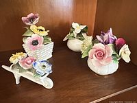 Overall view of four bone china floral figurines on shelf