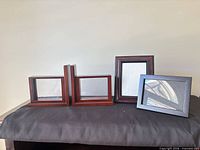 All four items: two wood bookends, wood frame, silver frame