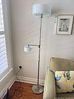 Full view of chrome floor lamp beside sofa