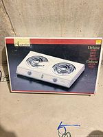 Front of retail box showing image of double burner cooktop and brand name