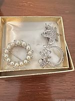 Box with faux pearl wreath brooch and rhinestone circle spray brooch