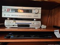 Shelf view showing Yamaha receiver, Panasonic VCR, Panasonic Blu-ray player stacked