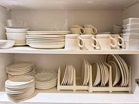 Shelved dinnerware showing plates, bowls, mugs and ramekins