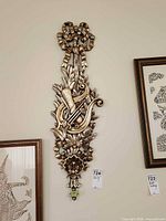 Full view of carved wood wall plaque hanging on wall