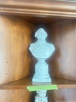 Full frontal view of porcelain bust on shelf