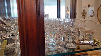 Cabinet view showing multiple clear and cut crystal stemware pieces and stemless snifters