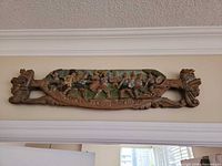 Full view of carved wooden medieval scene plaque mounted above doorway