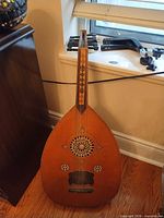 Full view of oud showing body shape, fingerboard, pegs