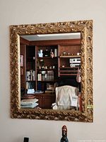 Front view of rectangular gilt mirror hanging on wall