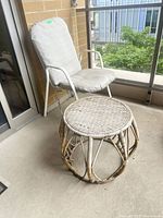 Chair with cushion beside round wicker table