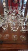 Group of wine glasses and champagne coupes on dresser
