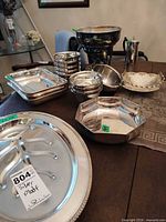 Group shot of most pieces: punch bowl, small bowls stack, trays, divided platter, octagonal bowl, coffee pot, pierced basket