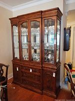 Front view of china cabinet showing glass doors, drawers, overall design