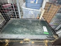 Closed trunk top showing green surface wear and riveted edge