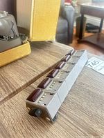 Oblique view of six linked mechanical counters showing burgundy buttons and reset knob