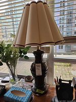 Full lamp showing base, shade, inline switch on desk