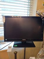 Front view of Toshiba TV showing screen, bezel, stand and tags