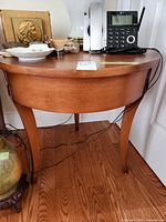 Full view of side table front showing round top, apron and legs