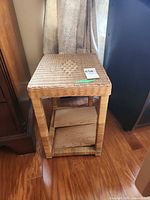 Front angled view of wicker and wood side table