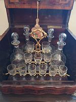 Open cabinet showing interior rack with decanters and glasses