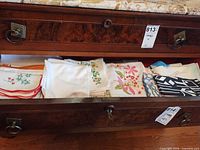 Drawer containing multiple folded handkerchiefs and napkins