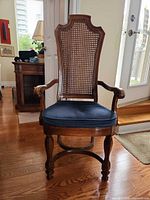 Full view of armchair showing caned back, arms, seat, legs