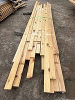 Bundled tongue-and-groove red pine boards laid on ground