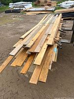 Full view of bundled 1x4 dressed pine boards on ground