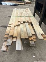 Stack of weathered 1x4 V-joint boards strapped together on pallet forks