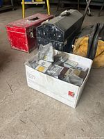 Three toolboxes and box of hardware grouped on floor