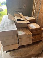 Stacked cardboard boxes on pallet showing light frames and other components