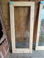 Full view of pine framed glass door leaning against wall