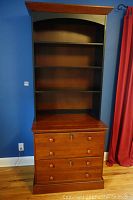 Full view of Ethan Allen bookcase with filing cabinet base under three open shelves, showcasing dark sides and back with brown top and drawer fronts.